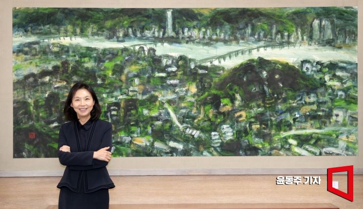 최호정 서울시의회 의장이 의장실에 걸린 서울의 '한강'이라는 작품 앞에서 포즈를 취하고 있다. 윤동주 기자