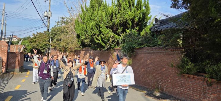 26일 국립한국방송통신대학교 광주·전남지역 총동문회와 대구·경북지역 총동문회 등 400여명이 광주 동구 무등산국립공원 둘레길 일대에서 열린 달빛 문화 탐방에서 산책을 하며 손을 흔들고 있다. 민찬기 기자