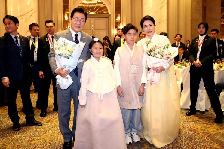 이재명 대통령과 김혜경 여사가 26일 말레이시아 쿠알라룸푸르 한 호텔에서 열린 동포 만찬 간담회에서 화동과 기념촬영을 하고 있다. 연합뉴스