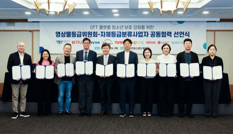 OTT 플랫폼 청소년 보호 강화를 위한 영상물등급위원회-자체등급분류사업자 공동협력 선언식에서 참석자들이 협약서를 작성한 뒤 기념 촬영하고 있다. 연합뉴스
