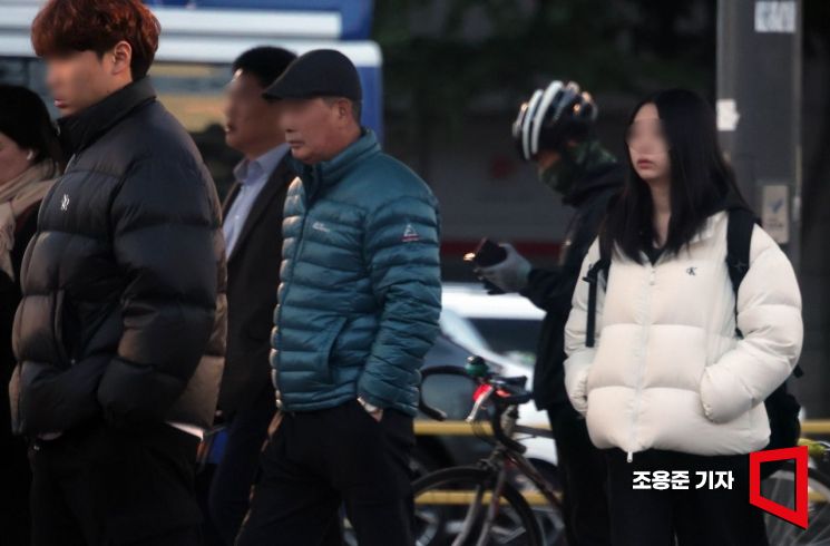 서울 아침 기온이 4도까지 떨어지면서 초겨울 날씨를 보인 27일 서울 마포구 공덕역 부근에서 출근길 시민들이 두툼한 패딩을 입고 발걸음을 옮기고 있다. 조용준 기자