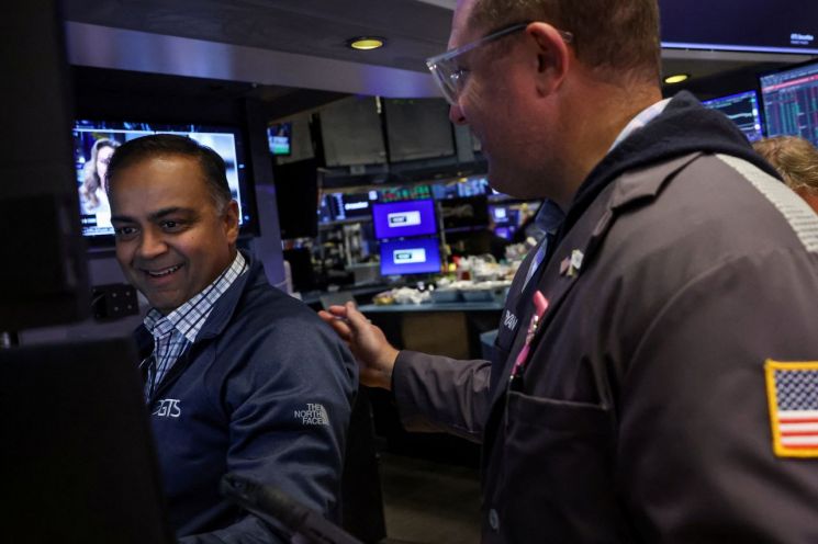 27일(현지시간) 미국 뉴욕증권거래소(NYSE) 거래장에서 트레이더들이 업무를 보며 환하게 웃고 있다. 로이터연합뉴스