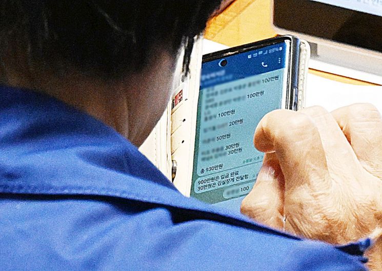 국정감사 기간 딸 결혼식으로 논란을 빚은 국회 과학기술정보방송통신위원장인 더불어민주당 최민희 의원이 26일 국회 본회의장에서 축의금과 관련한 텔레그램 메시지를 보고 있다. 연합뉴스