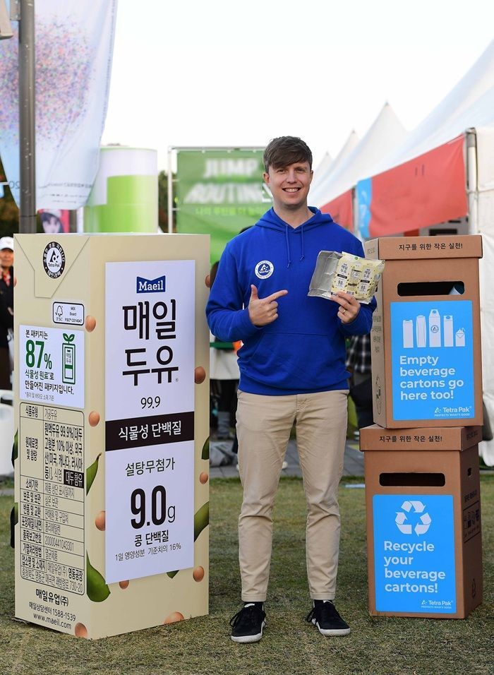 국내 최초 종이 기반 보호층 멸균팩을 적용한 매일두유 99.9 모형 앞에서 멸균팩을 들고 있는 테트라팩 코리아 브랜드 앰버서더 줄리안 퀸타르트