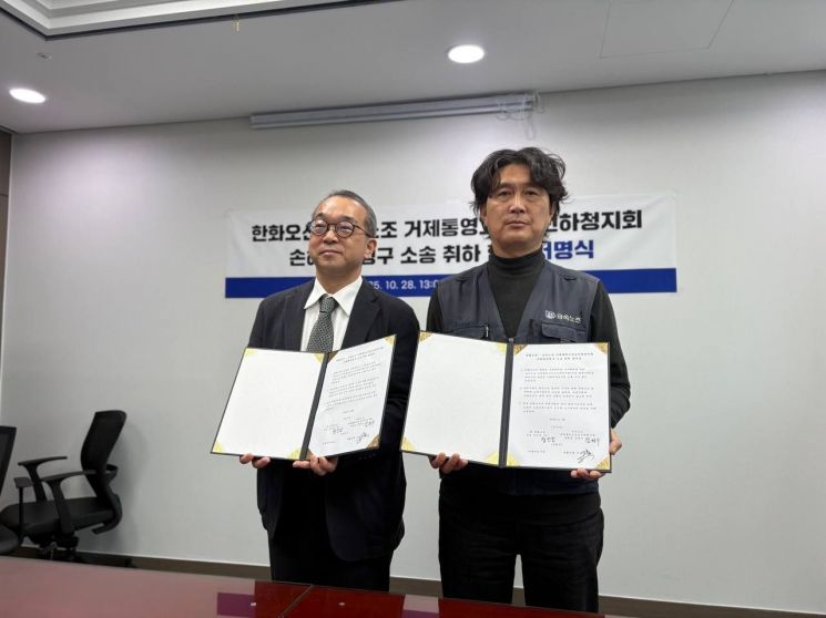 한화오션과 금속노조 경남 거제통영고성 조선하청지회 관계자가 손해배상 청구소송 취하 합의문을 들고 사진을 찍고 있다. 금속노조 경남지부 제공