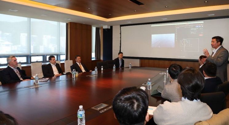 폴 르윈(Paul Lwin) 해벅AI(HavocAI) CEO(맨 오른쪽 발표자)가 한화 임직원들에게 하와이 앞 바다에 대기중인 해벅AI의 무인수상정을 한화오션 거제사업장에서 원격통제하는 기술 시연을 선보이고 있다. 한화 제공