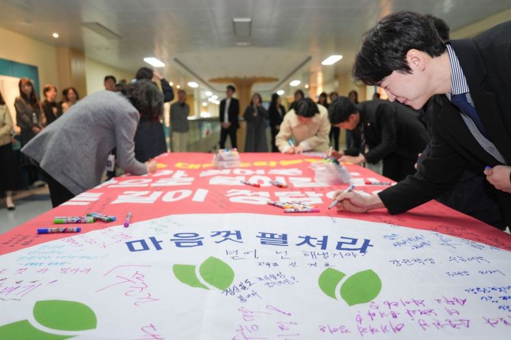 강원특별자치도교육청 직원들이 대형 펼침막에 2026학년도 대학수학능력시험(이하 수능)을 응원하는 글을 적고 있다. 강원도교육청 제공