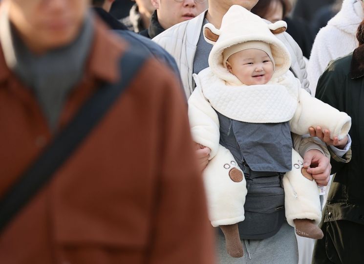 아침 기온이 낮아져 초겨울 날씨를 보인 지난 28일 서울 종로구 광화문광장 인근 횡단보도에서 한 아이가 겨울옷을 입고 이동하고 있다. 연합뉴스