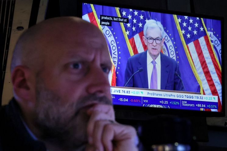 29일(현지시간) 미국 뉴욕증권거래소(NYSE) 거래장에서 한 트레이더가 업무를 보고 있는 가운데, 뒤편 스크린에서 제롬 파월 미 연방준비제도(Fed) 의장이 기준금리 인하 발표 후 기자회견을 하는 모습이 방영되고 있다. 로이터연합뉴스