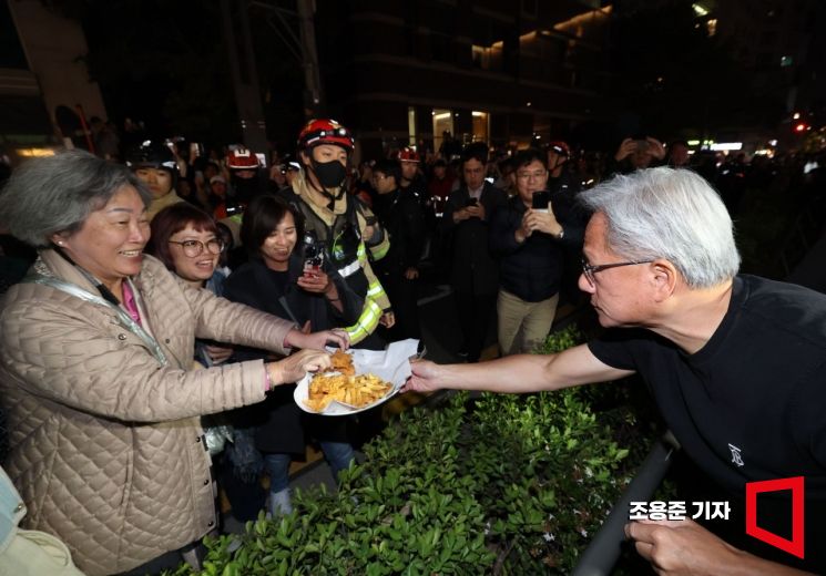 젠슨황 엔비디아 최고경영자가 30일 이재용 삼성전자 회장, 정의선 현대자동차그룹 회장과 서울 강남구 깐부치킨에서 회동 중 시민들에게 치킨을 내밀고 있다. 조용준 기자