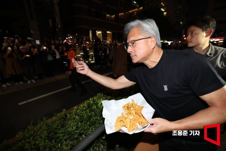 30일 젠슨황 엔비디아 최고경영자(CEO)가 이재용 삼성전자 회장, 정의선 현대자동차그룹 회장과 서울 강남구 깐부치킨에서 회동 중 시민들에게 치킨을 내밀고 있다. 조용준 기자