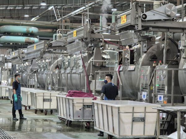 C&T VINA 2공장 노습. 직원들이 염색 기기 안에서 천을 빼내고 있다. 염색기에는 1000kg 단위로 원단을 넣을 수 있다. 폴리에스테르 등 화학섬유는상대적으로 130도의 고온 고압에서 빠르게 염색하는 것이 특징이다.