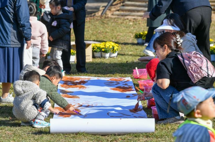 아이들이 부모님과 숲 그리기 체험을 하고 있다.