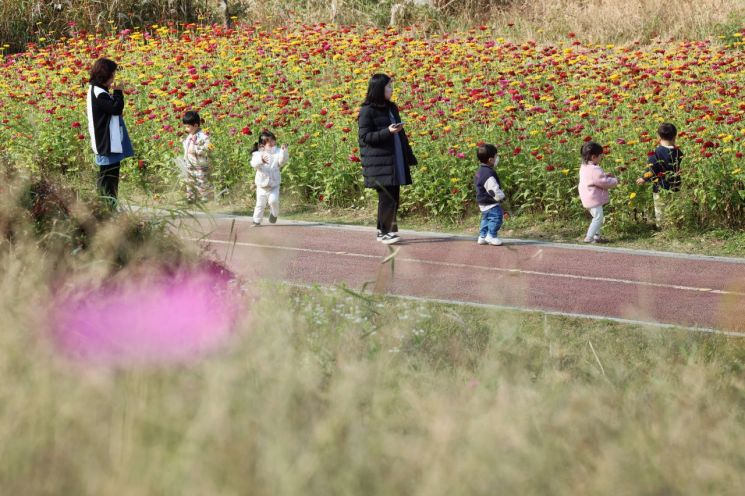 4일 광주 북구 영산강 둔치 꽃밭에서 아이들이 산책하고 있다. 연합뉴스