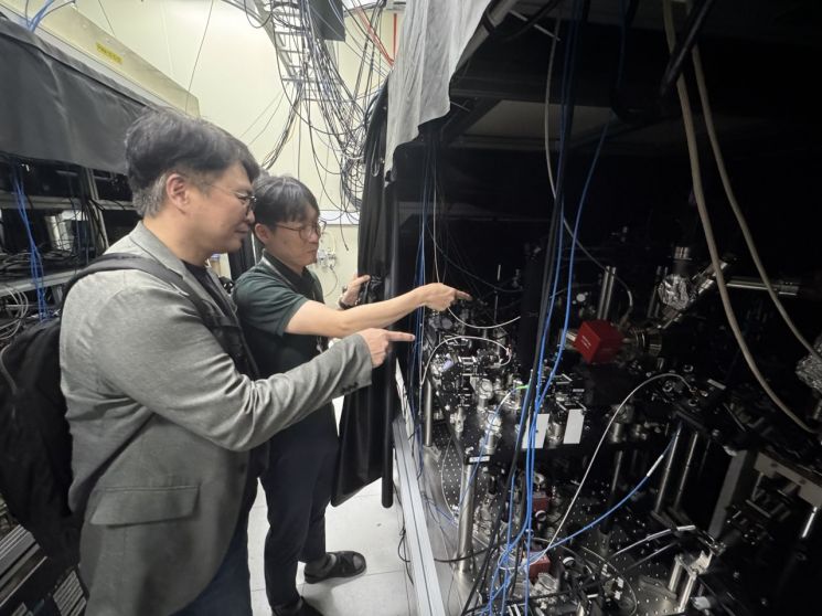 문종철 한국표준과학연구원 박사(오른쪽)가 연구실에서 백종민 아시아경제 테크 스페셜리스트에게 중성원자 양자컴퓨터 연구 장비를 설명하고 있다. 사진=한국표준과학연구원