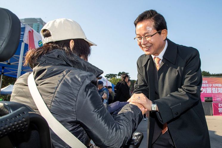 ‘영등포구 지역명소 어울림 체육대회’에 참석한 최호권 영등포구청장이 한 장애인과 인사를 나누고 있다. 영등포구 제공.