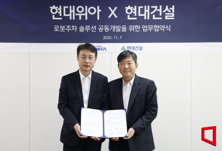 백익진 현대위아 모빌리티솔루션사업부 상무(왼쪽)가 7일 경기도 의왕시 현대위아 의왕연구소에서 열린 ‘로봇 친화형 주차솔루션 공동개발을 위한 업무협약식’에서 김재영 현대건설 기술연구원장과 기념 촬영을 하고 있다. 현대위아