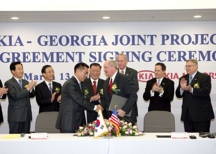 2006년 기아 조지아공장 투자계약식에서 정몽구 명예회장(사진 뒷줄 왼쪽에서 세번째)이 지켜보는 가운데 정의선 회장(사진 앞줄 왼쪽)과 소니 퍼듀 조지아 주지사가 투자 계약서에 서명한 후 악수하고 있다. 현대차그룹 제공