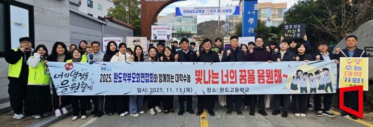 완도고등학교 시험장 앞에서 이철영 완도교육장과 교육청 직원들이 학부모와 교사, 후배들과 함께 수험생들을 응원하고 있다. 이준경 기자