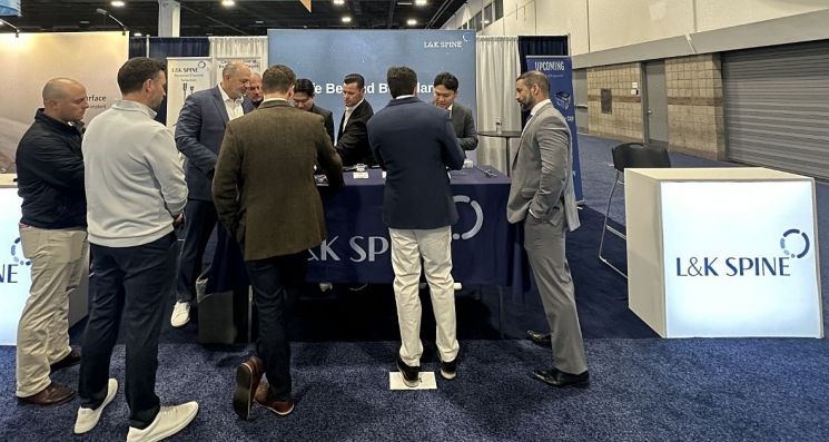 엘앤케이 스파인 관계자가 'NASS 2025'에서 척추 관련 병원 의료진에게 제품을 설명하고 있다. 엘앤케이바이오메드.