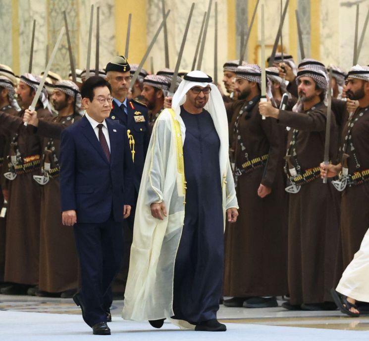 이재명 대통령이 18일(현지시간) 아랍에미리트(UAE) 아부다비 대통령궁에서 열린 국빈방문 공식 환영식에서 무함마드 빈 자이드 알 나흐얀 UAE 대통령과 사열대로 이동하고 있다. 연합뉴스