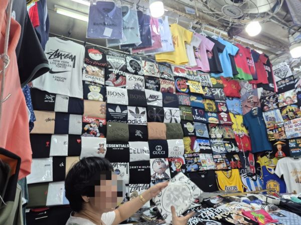 스투시, 셀린트, 구찌 등 명품 티셔츠들이 매대에 걸려있다.