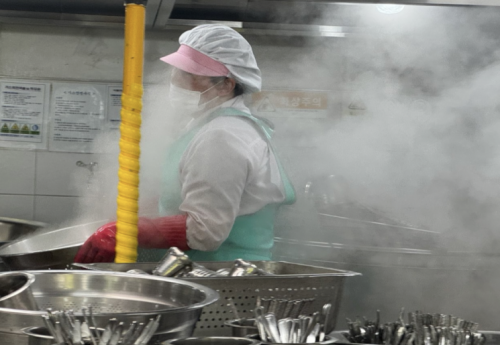 광주의 한 학교 조리실에서 땀과 증기로 젖은 조리 노동자가 뜨거운 열기 속에서 식기를 세척하고 있다. 학교비정규직노조 제공