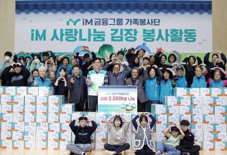 성태문 iM금융지주 그룹가치경영총괄 부사장(앞줄 왼쪽 다섯 번째)과 iM가족봉사단이 주말 김장 봉사활동 기념 촬영을 하고 있다. iM금융지주
