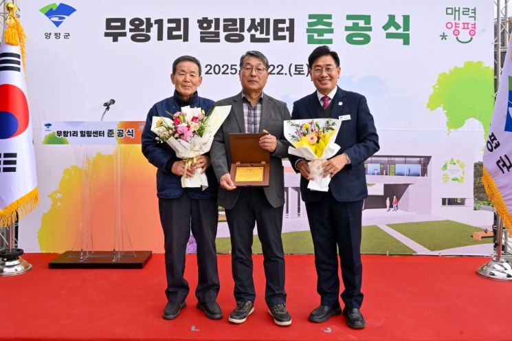 전진선 양평군수(오른쪽)가 지난 22일 지역 주민들의 숙원사업이었던 지평면 '무왕1리 힐링센터' 준공식에서 유공자 표창을 수여한 후 기념촬영을 하고 있다. 양평군 제공