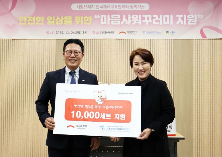 왼쪽부터 희망브리지 신훈 사무총장과 서울장애인가족지원센터 김남연 광역센터장이 재난 취약계층을 위한 마음샤워꾸러미 1만세트 전달식을 가진 후 기념촬영 하고 있다. 희망브리지