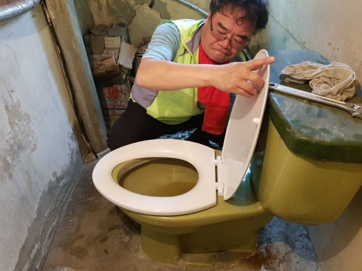 화장실 보수 공사를 하고있는 최광석씨. 광양시 제공
