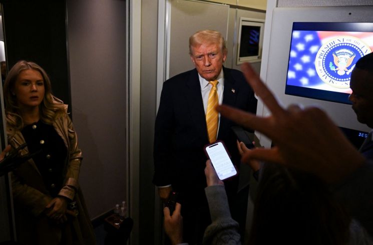 도널드 트럼프 미국 대통령이 2025년 11월 14일 미국 플로리다로 향하는 에어포스원에 탑승한 캐롤라인 레빗 백악관 대변인 옆에서 기자들과 대화하고 있다. /로이터연합뉴스