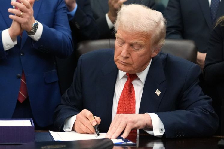 워싱턴 백악관 집무실에서 법안에 서명하고 있는 도널드 트럼프 대통령. AP연합뉴스.