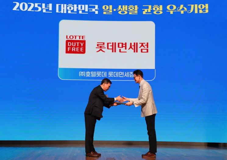 박상호 롯데면세점 경영지원부문장(오른쪽)이 이명로 중소기업중앙회 상무로부터 2025 일·생활 균형 우수기업 상을 받고 있다. 롯데면세점 제공