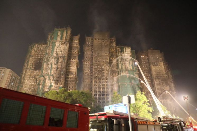 27일(현지시간) 오후 9시쯤 홍콩 북부 타이포의 고층 아파트 단지 '웡 푹 코트'(Wang Fuk Court)에서 소방당국이 남아있는 불을 끄기 위해 화재 진압을 하고 있다. 연합뉴스