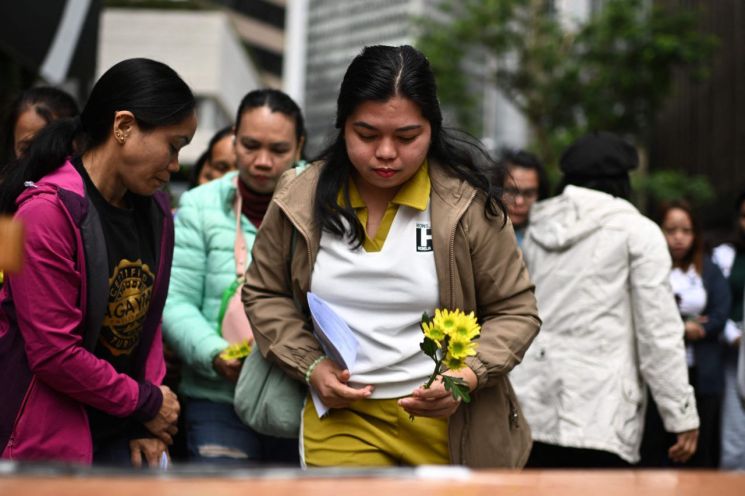 필리핀 국적자들이 홍콩 중앙구 타이포에서 발생한 화재 희생자들을 위한 지역사회 기도회에 참석하고 있다. AFP연합뉴스.