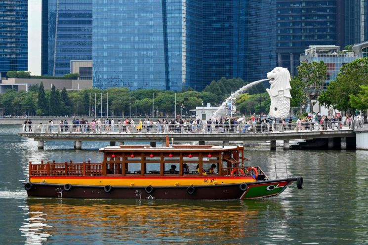 지난달 21일 싱가포르 마리나베이의 머라이언 석상 주변에 모여있는 관광객들의 모습. AFP연합뉴스
