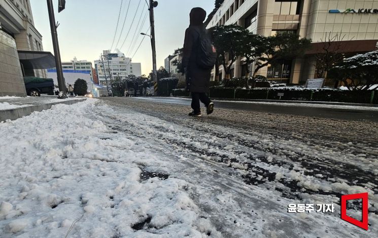 Citizens cautiously walk along a side street in Jung-gu, Seoul, where snow removal work was insufficient, as roads across downtown Seoul froze overnight due to subzero temperatures following heavy snowfall in the metropolitan area the previous day on the 5th. 2025.12.05 Photo by Dongju Yoon