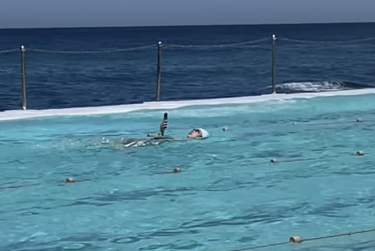 "The World Is Going Crazy": Woman Spotted at Pool Doing Backstroke While Holding a Smartphone