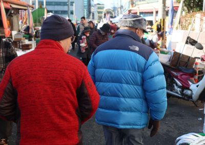 최저 기온이 영하를 기록한 3일 오전 경남 창원시 마산합포구 마산어시장에서 두꺼운 패딩 점퍼 등을 착용한 시민이 찬 바람을 막으며 이동하고 있다. 연합뉴스