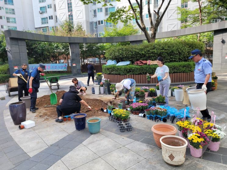 올해 '공동주택 우수관리단지'로 선정된 화성 병점역 동문굿모닝힐 아파트 주민들이 폐화분을 활용해 단지 내 꽃길을 조성하고 있다. 화성시 제공