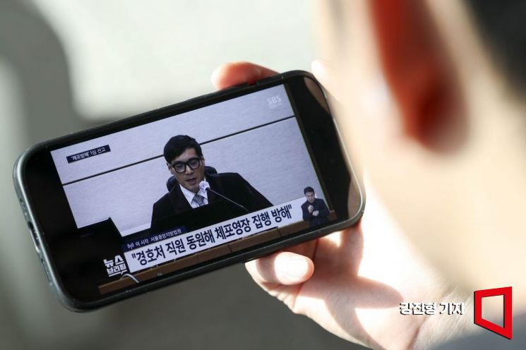 [포토] 휴대전화로 윤석열 전 대통령 1심 선고 보는 시민