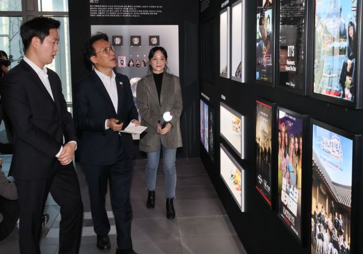 김민석 국무총리가 21일 서울 용산구 하이브 사옥을 방문해 홍보부스를 살펴보고 있다. 연합뉴스