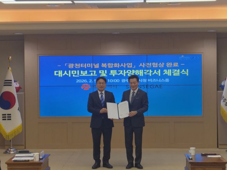 Kang Gijeong光州市长与Shinsegae代表理事Park Juhyung5日上午在光州市厅商务室举行的“光川客运站复合化项目投资谅解备忘录签署仪式”上举起协议书合影。宋宝贤 记者提供