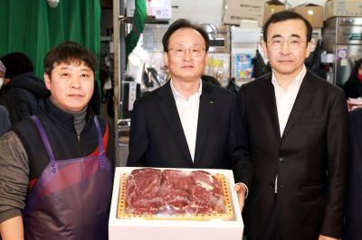 11일 서울 마포구 망원시장에서 열린 2026 설맞이 전통시장 사랑나눔 행사에서 이환주 KB국민은행장(가운데)과 이세훈 금융감독원 수석부원장(오른쪽)이 식료품을 구입하고 기념촬영을 하고 있다. 국민은행