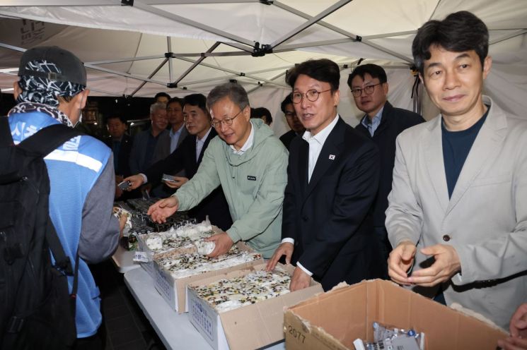 지난해 10월 새벽인력 시장을 찾아 근로자들에게 떡을 나눠주고 있는 김민석 국무총리. 연합뉴스.