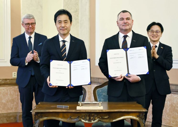 지난 16일(현지시간) 체코 프라하 총리실에서 열린 두산에너빌리티두산스코다파워 터빈 공급 계약 서명식에서 김정관 산업통상부 장관(오른쪽 뒤)과 카렐 하블리첵 체코 산업통상부 장관(왼쪽 뒤)이 서명을 마친 각사 임원들과 기념촬영을 하고 있다. 산업통상부.