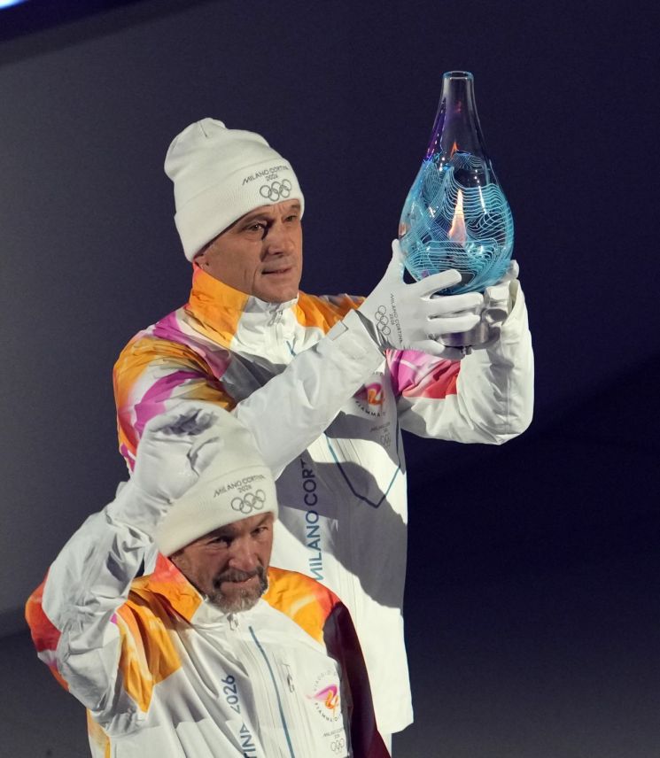 2026 밀라노·코르티나 동계올림픽 성화가 유리병에 담겨 23일(한국시간) 폐회식이 열린 '아레나 디 베로나' 안으로 옮겨지고 있다.      [사진 제공= 신화연합뉴스]