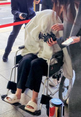약에 취한 상태로 외제 SUV 차량을 몰고 반포대교를 달리다 한강 둔치로 추락한 운전자 A씨가 27일 서울 마포구 서부지방법원에서 열린 구속 전 피의자 심문(영장실질심사)에 옷으로 얼굴을 가리고 휠체어를 탄 채 출석하고 있다. 연합뉴스