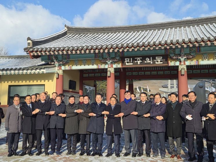 지난 1월 2일 오전 광주 북구 국립5·18민주묘지 민주문 앞에서 광주·전남 주요 인사들이 손을 맞잡고 기념촬영을 하고 있다. 송보현 기자